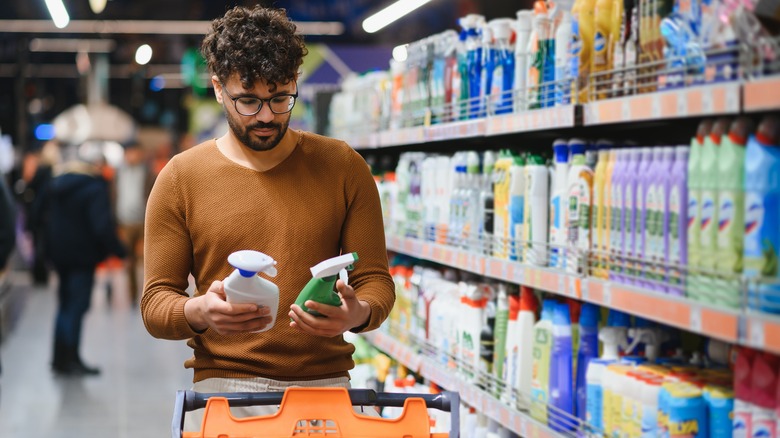 Man comparing two cleaning products in store