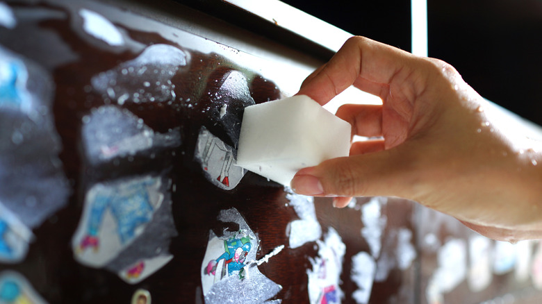 person cleaning stickers off with magic eraser