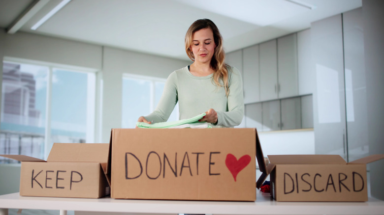 Woman decluttering home into different boxes