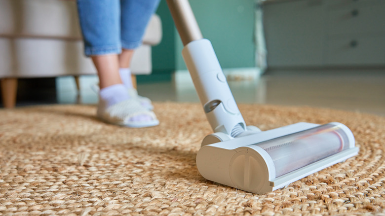 Close up of vacuum cleaner with someone using it in the background