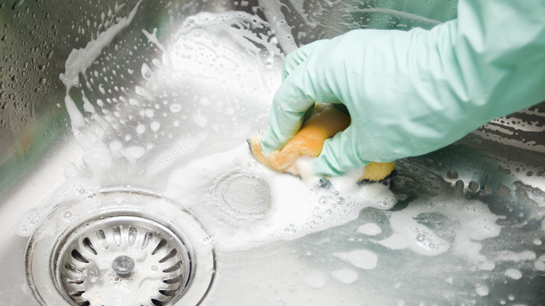 Person scrubbing kitchen sink