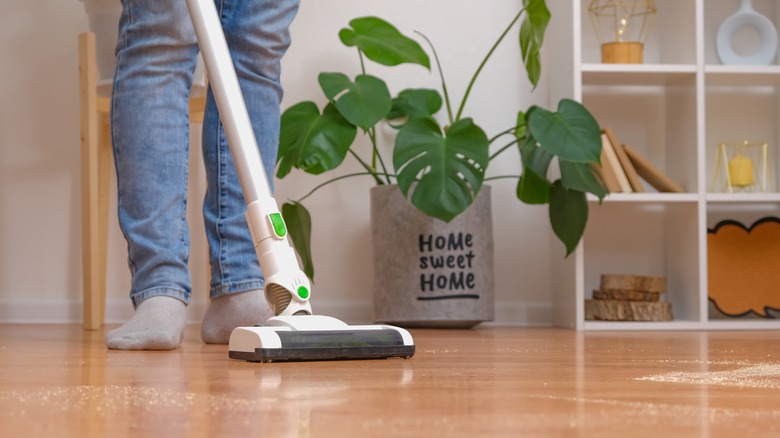 Person vacuuming hardwood floor