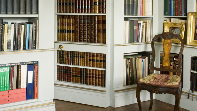 A secret bookshelf door open to reveal a space behind