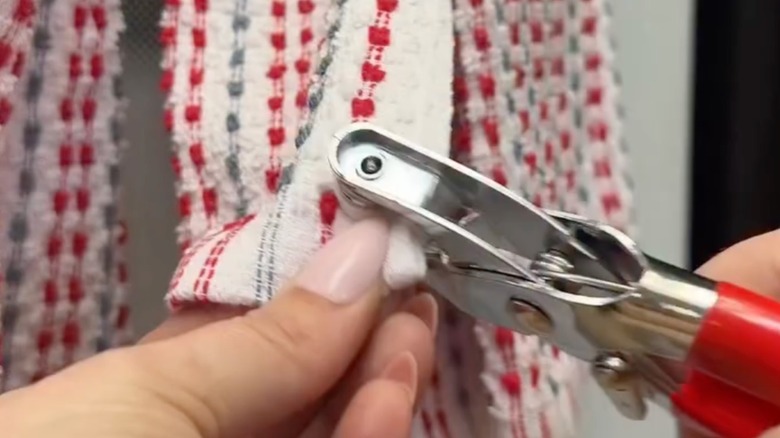 Person adding snap buttons to a kitchen towel