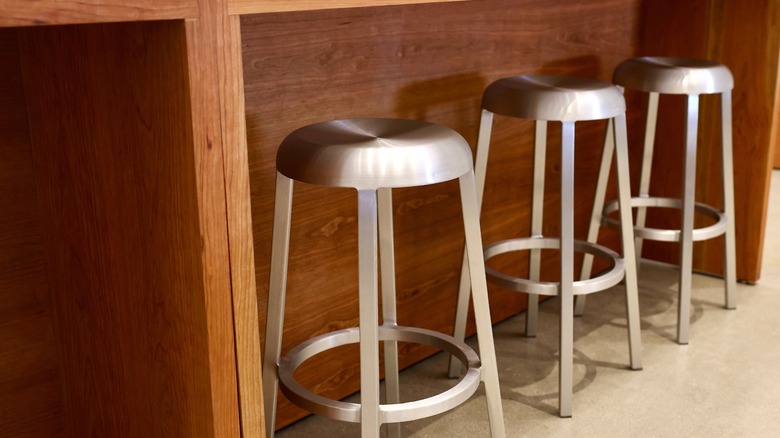 Metal bar stools under wood console table