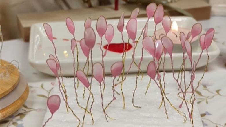 Twisted loop of wire dipped in nail polish dry while standing in a piece of styrofoam.