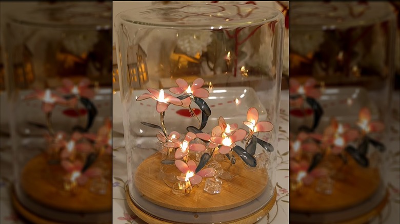 A light-up flower decor piece made from wire and nail polish inside an upturned glass jar