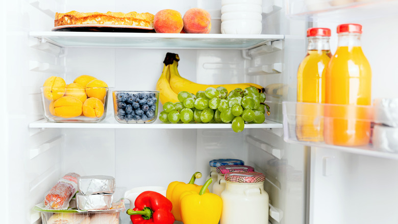 Refrigerator door with fruits, cheese, and orange juice