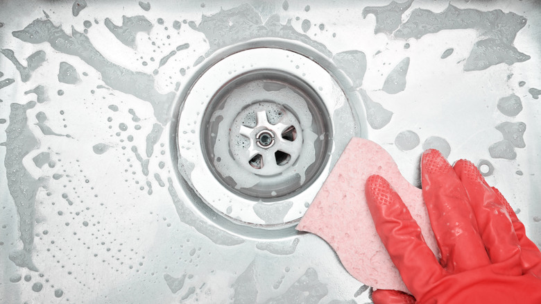 hand using sponge in sink