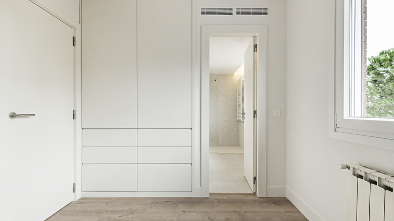 A white built-in closet in a small bedroom