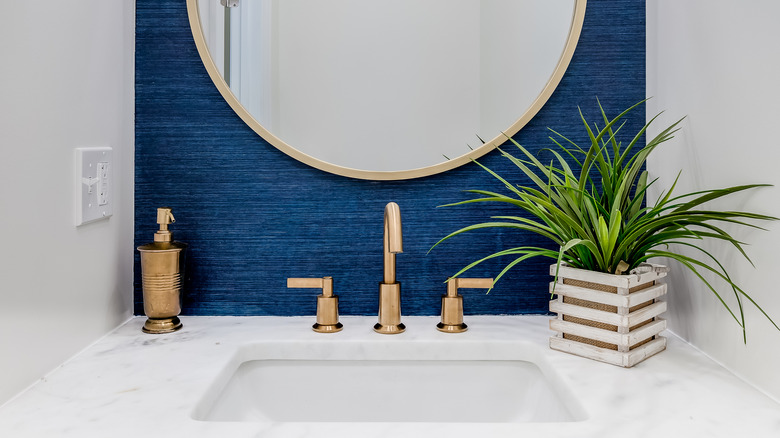 Round mirror above narrow sink