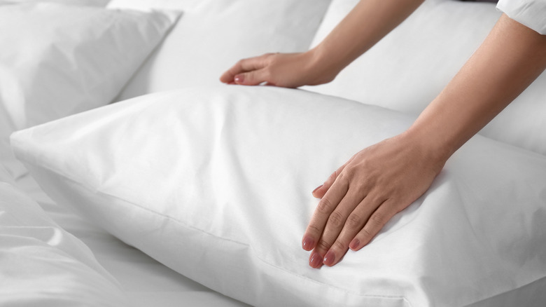 Person's hands plumping up pillow