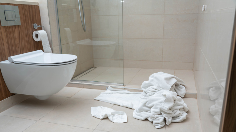 Woman folding towels in bedroom
