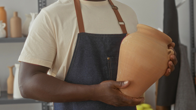 Person holding ceramic clay vase