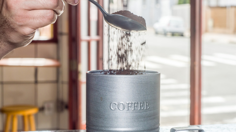 man with a spoon and coffee canister