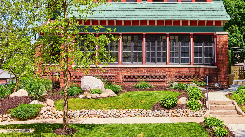 A large boulder blocks the section of a house's foundation
