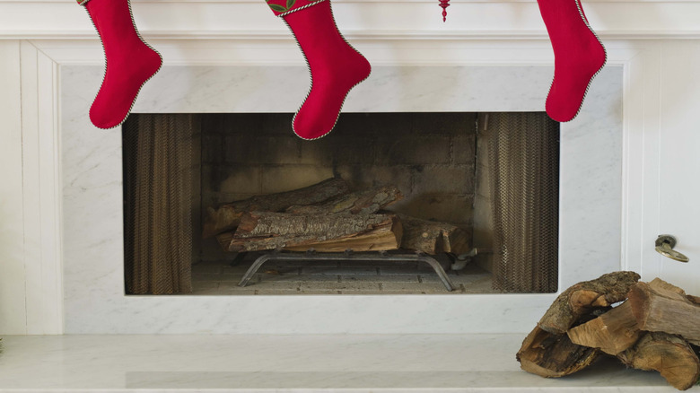 Christmas garland and red stockings on white fireplace mantle