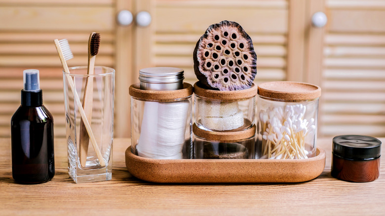 Small glass jars stacked on each other with Q-tips and cotton pads