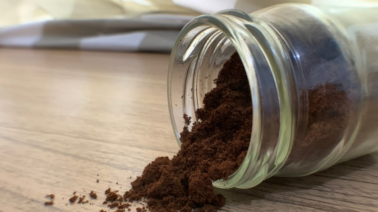 Coffee jar laying on side with spilled grounds