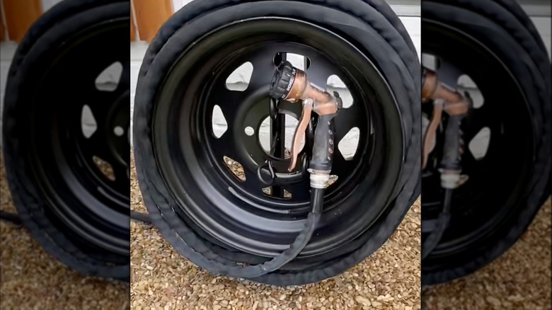 Old tire rim with garden hose wrapped around