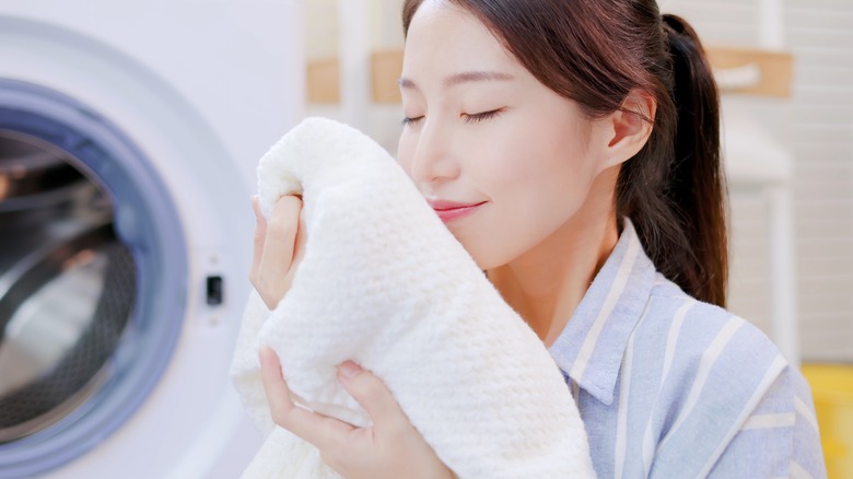 happy woman smelling fresh laundry