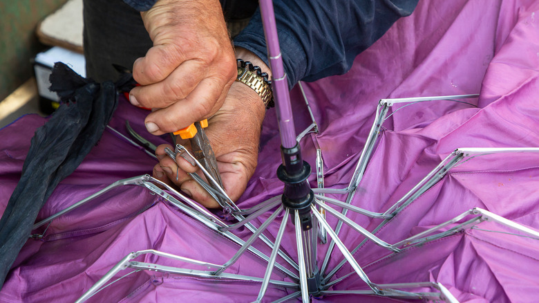 person removing canopy from umbrella