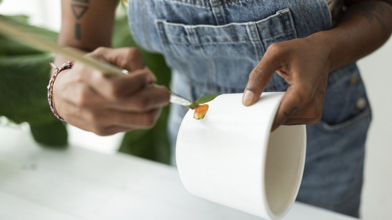 Person painting upcycled planter