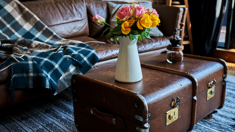 A vintage trunk with coffee and vase on top