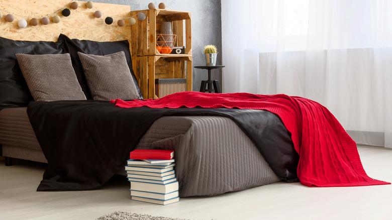A bedroom in which red and black are used as accents.