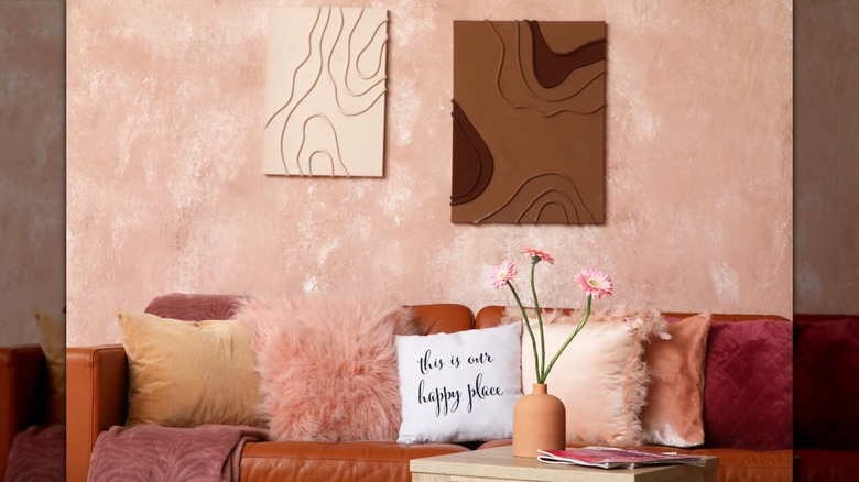 A living room with a brown and pink color palette