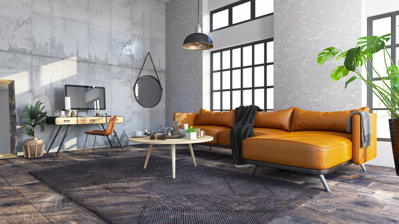 Gray room with wood accents and jewel toned couch in orange
