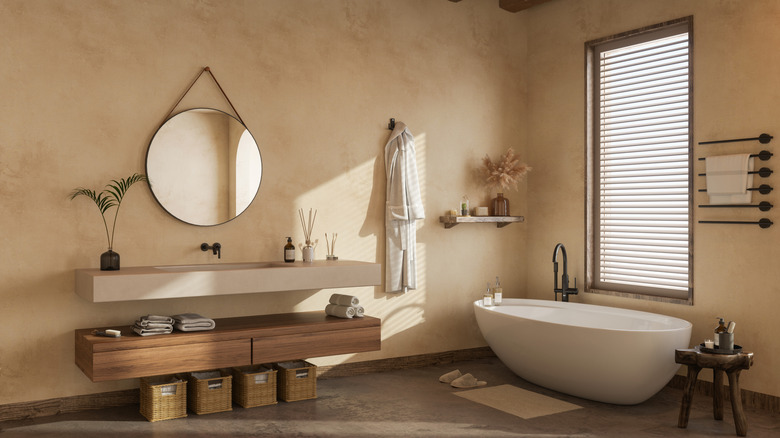 A bathroom with Venetian plaster treated walls, a floating vanity, houseplants, and a standalone tub.