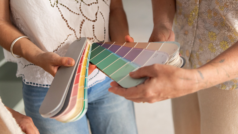 Two women holding paint swatches