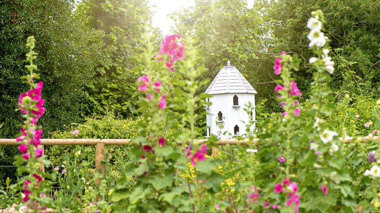 A simple bird house in a garden.