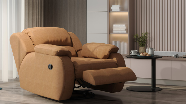 A beige recliner chair with a small table next to it.
