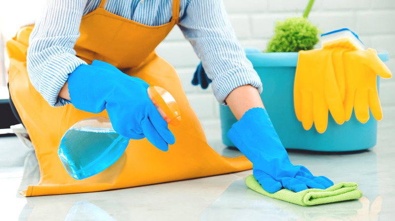 Kneeling woman cleaning marble floor