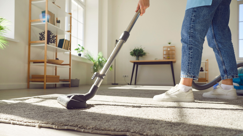 Woman vacuuming a rug