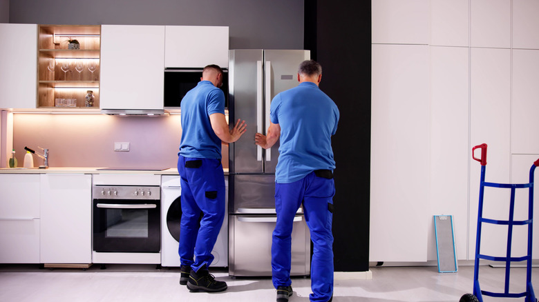 Appliance installers connecting a refrigerator