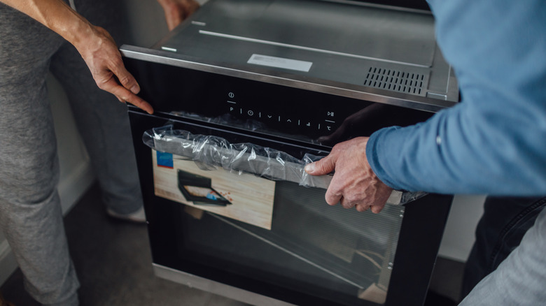 Two people installating an oven
