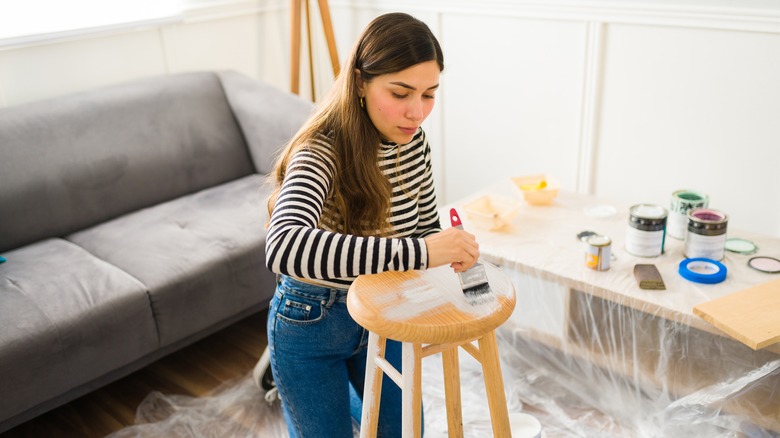 woman painting wood stool