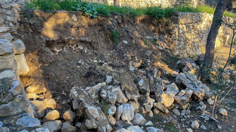 A large collapsed stone retaining wall