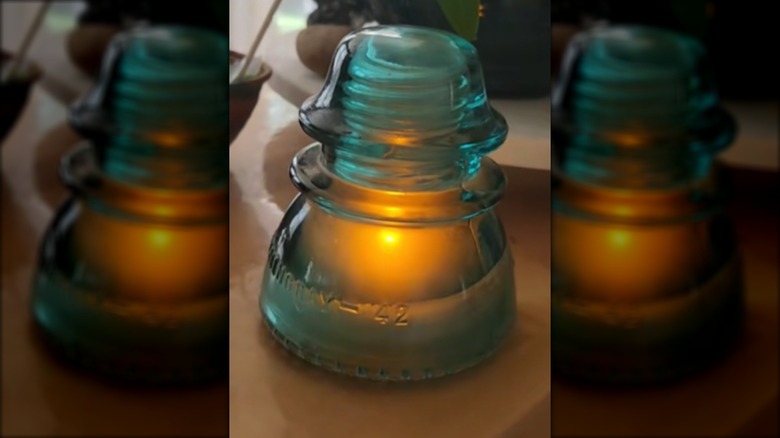 Glass insulators with battery-operated tea lights inside