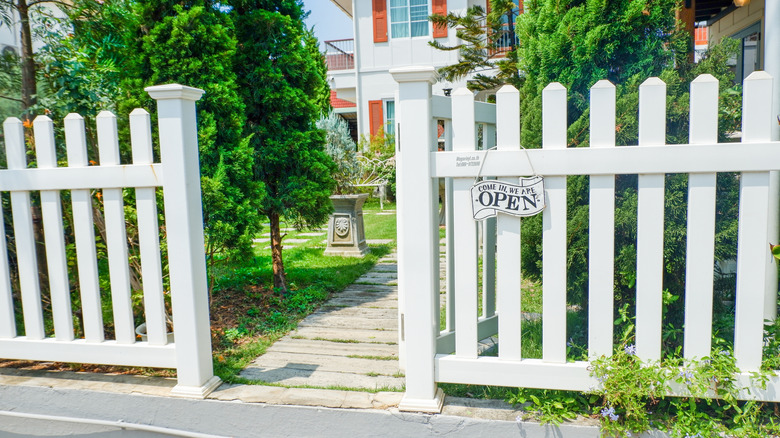 White vinyl fence with an open gate