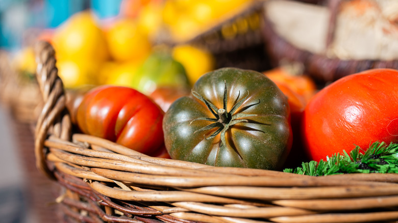 Colorful heirloom tomatoes displayed in a wicker basket, showcasing the variety