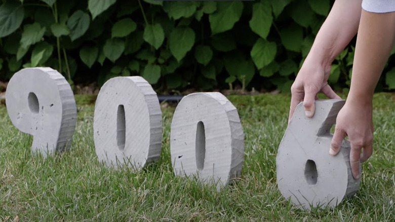 person setting up concrete numbers 