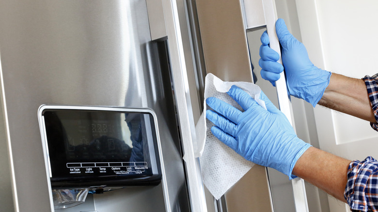person wiping fridge