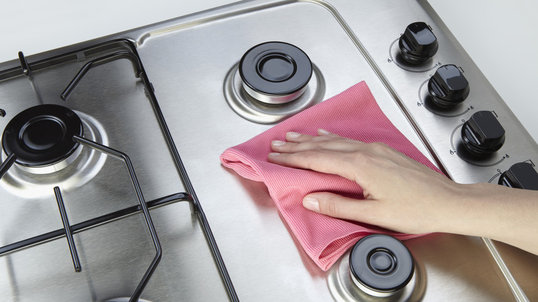 woman cleaning stove top