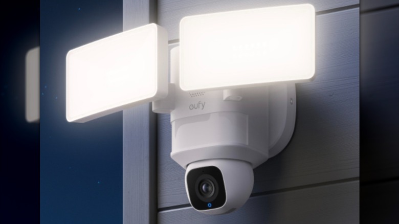 Security camera and floodlight mounted to the side of a house