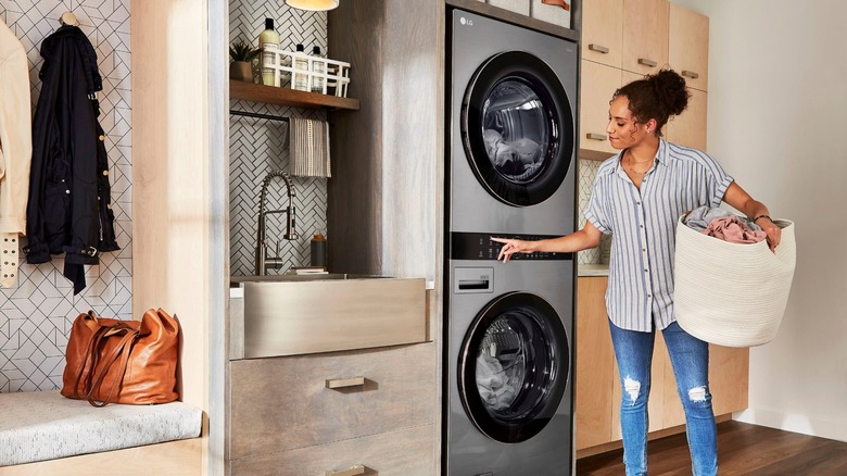 Person doing laundry in an LG washing machine and dryer unit