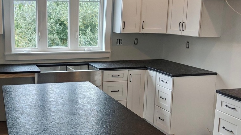 A white kitchen with black leathered granite countertops